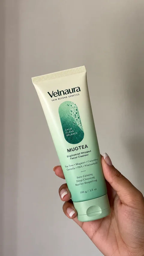 A hand holds a Mugtea tube in soft, warm light.